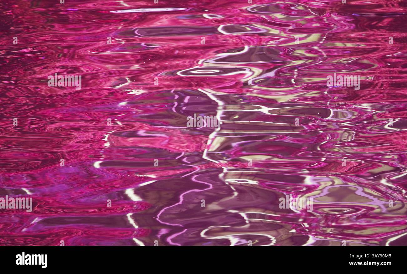 Atemberaubende Pop Art surreale magentafarbene Wasseroberfläche im Sonnenlicht Stockfoto