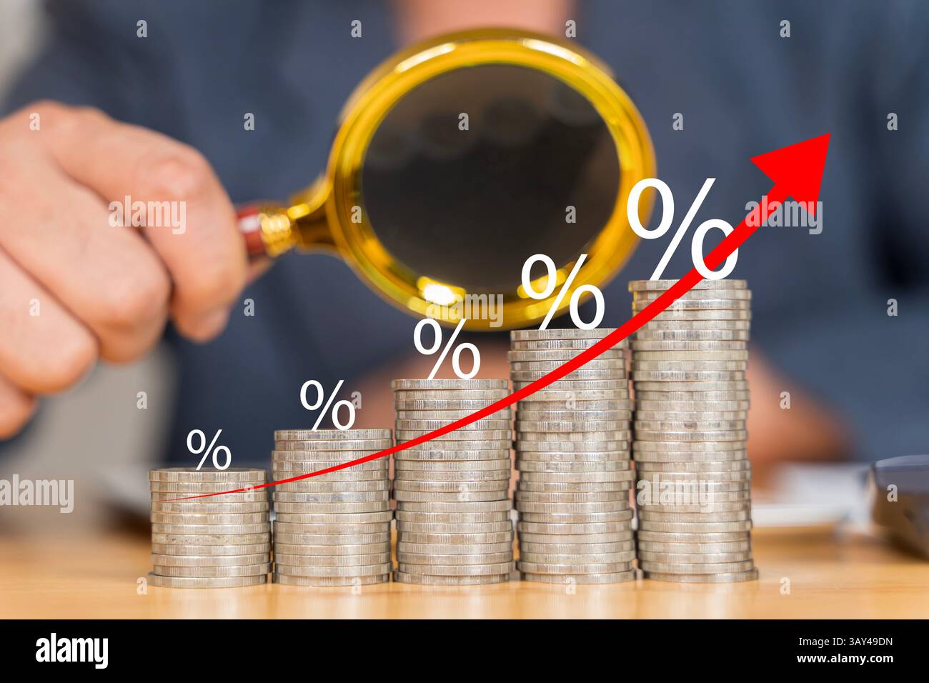 Die Hände von Geschäftsleuten konzentrieren sich auf das Geld. Sie benutzen eine Lupe, um ein Geld zu sehen. Finanz- und Geschäftswachstumskonzept. Geschäftsmann mit Lupe wi Stockfoto