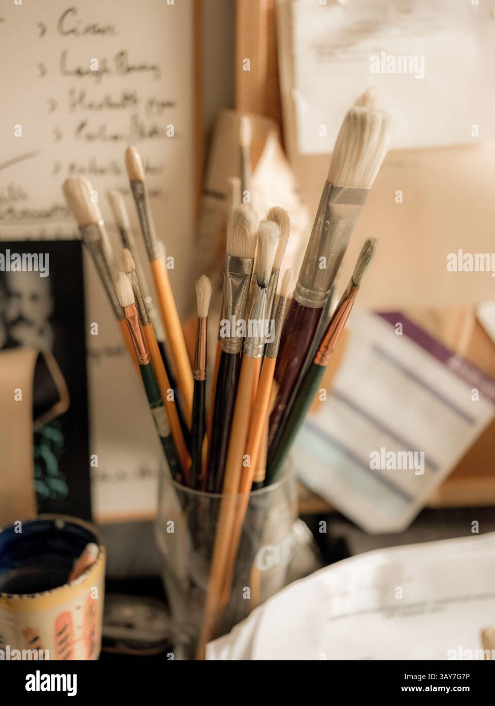 Pinsel auf einem Schreibtisch und Tageslicht im Studio eines Künstlers. Stockfoto
