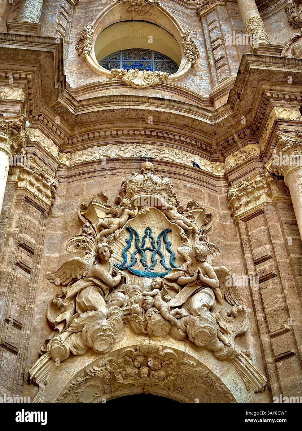 Eine detaillierte Ansicht einer Kathedralfassade mit Engelskulpturen und religiösen architektonischen Elementen. - Smartphone-aufgenommenes Stockfoto