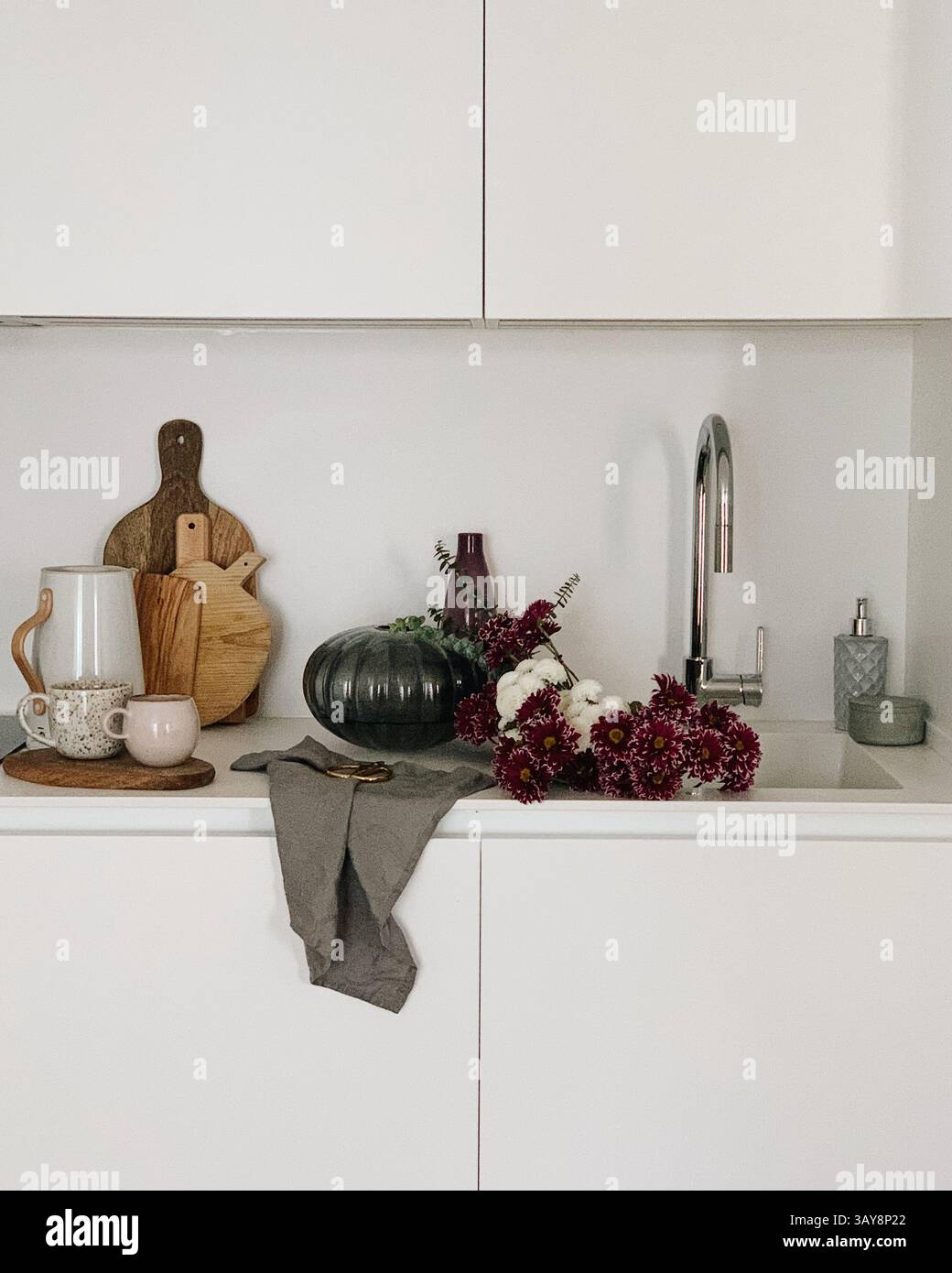 Moderne, minimalistische Küche mit Blumen und rustikaler Einrichtung Stockfoto