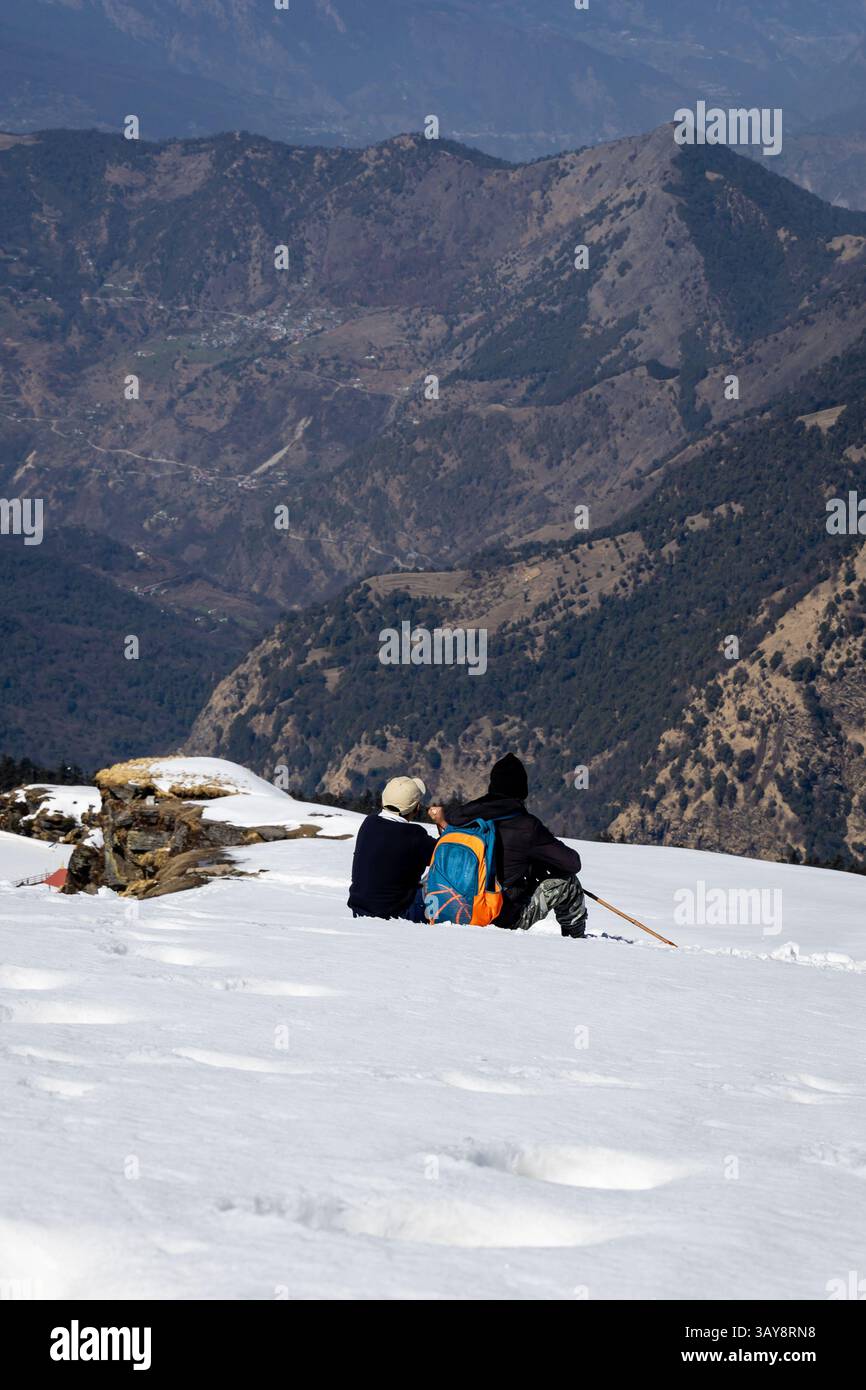 Wanderer, die sich bei den snowcap Mountain Trials mit atemberaubender Aussicht entspannen, werden am Chopta Tungnath Himalaya Berg Chandrashila Trek uttarakhand i aufgenommen Stockfoto