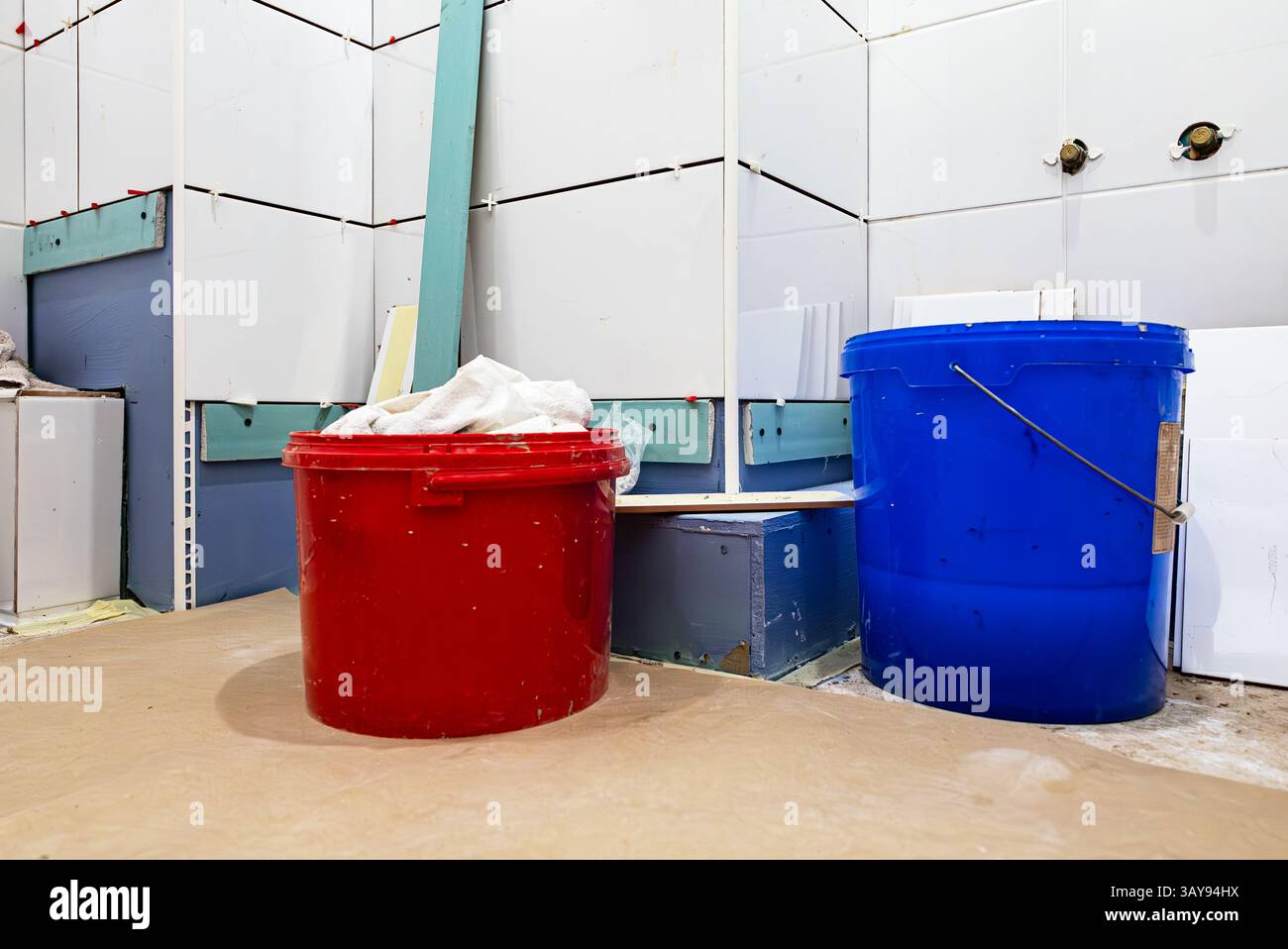 Neues Badezimmer mit frischen Fliesen und Arbeitseimern. Stockfoto