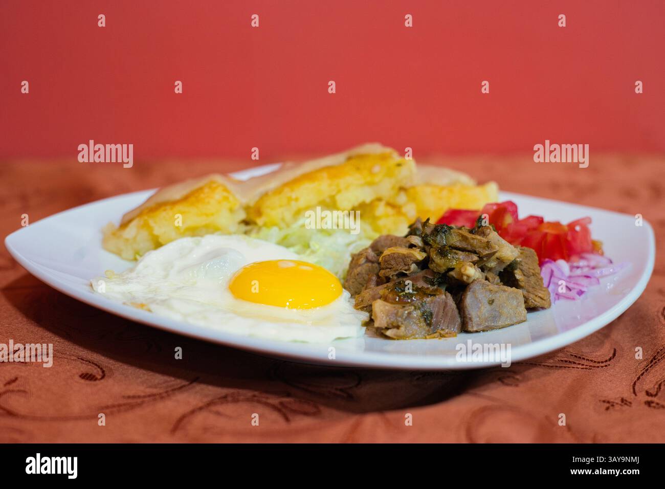Ein lebendiger und appetitlicher Frühstücksteller mit wunderschön gekochten Ei, herzhaftem Fleisch und frischem Gemüse Stockfoto