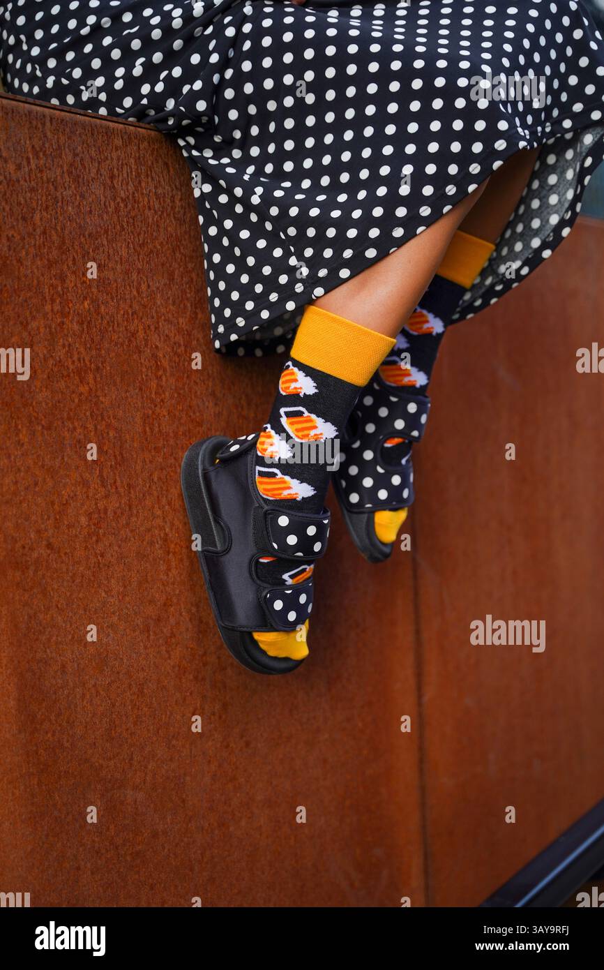 Schrullige Mode: Bunte Socken mit Streifen- und Bienenmustern auf rosa Hintergrund Stockfoto