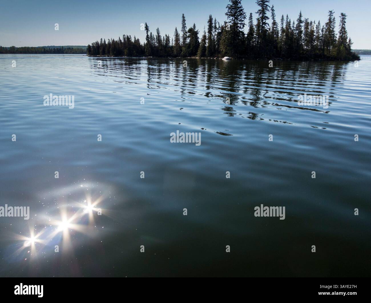 Sonne funkelt auf See umgeben von Wald, Dore Lake, Saskatchewan, Kanada Stockfoto