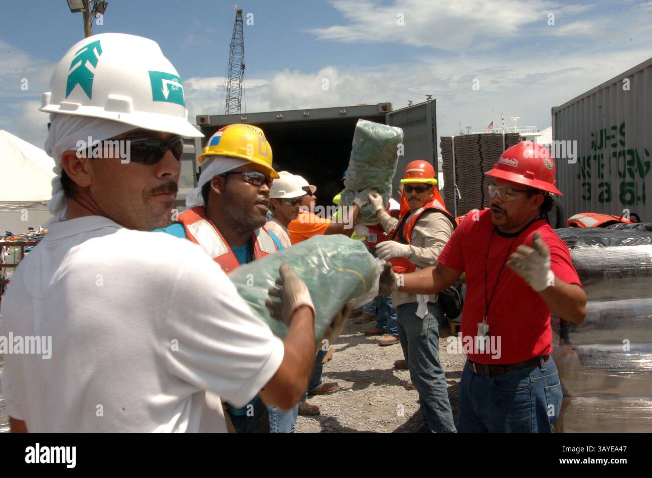 29. Juni 2010 - Branch Terrebonne, Louisiana, USA - Auftragnehmer transportieren Taschen mit Snare Boom aus einem niedrig gelegenen Gebiet in Branch Terrebonne Parish, La, in einen Container, um sie am Montag vorübergehend zu verlegen, da dort Hochwasser im Bereitstellungsbereich erwartet wird. Ausrüstung, die anfällig für weggespült werden könnte, wurde wegen einer Flut bewegt, die einen Fuß höher als normal war. In der Nähe gesichert, kann es schnell wieder eingesetzt werden, sobald die Gezeiten im Laufe dieser Woche wieder normal sind. Die Deepwater Horizon Ölpest ist eine massive Ölpest im Golf von Mexiko, die heute als die größte Offshore-Ölpest in der Geschichte der USA gilt. Stockfoto