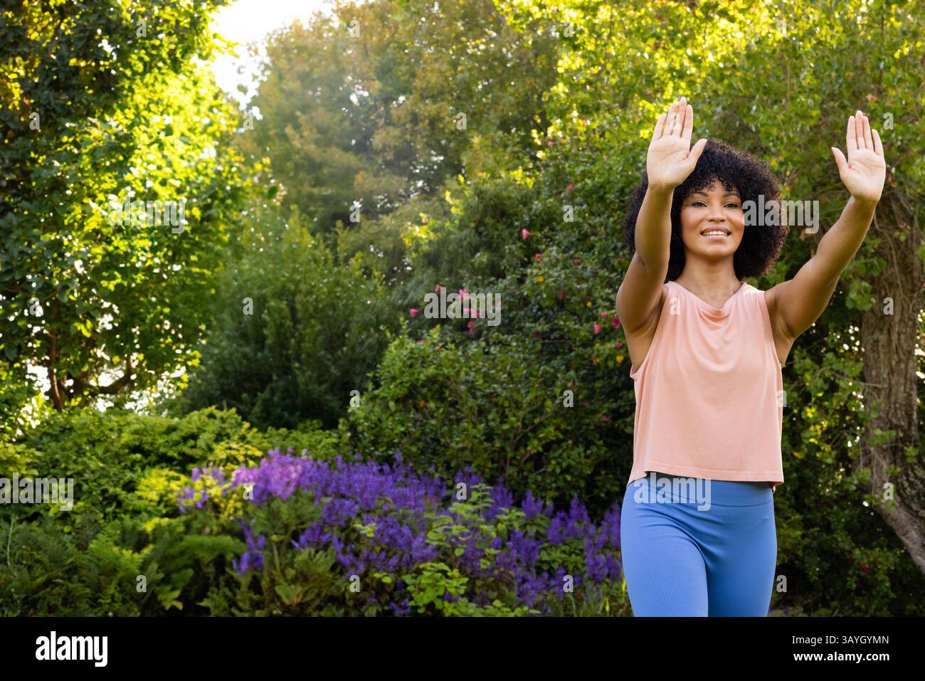 Frau übt Tai Chi in üppiger Gartenumgebung, mit Fokus auf Balance und Wellness, Kopierraum Stockfoto