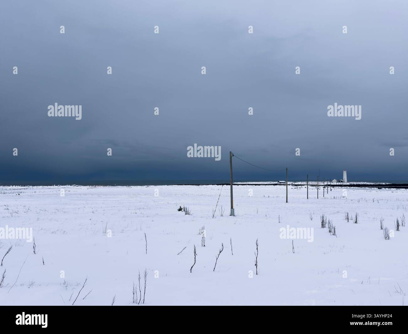 Schneebedecktes Feld mit dramatischem grauem Himmel Stockfoto