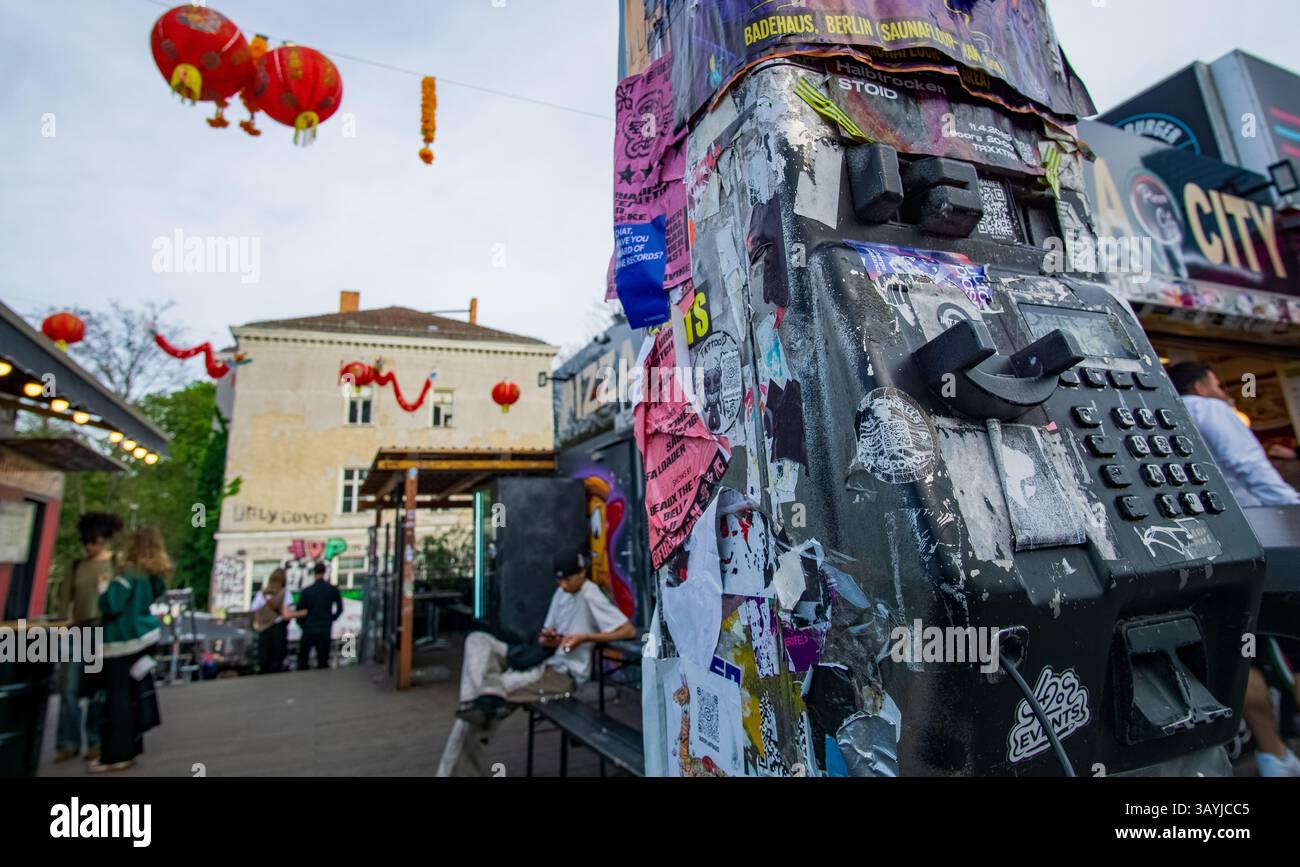 Stark aufgeklemmtes öffentliches Telefon am Eingang des ROHEN Kulturkomplexes in Friedrichshain, Berlin – ein anschauliches Beispiel für urbanen Ausdruck und Verfall. Stockfoto