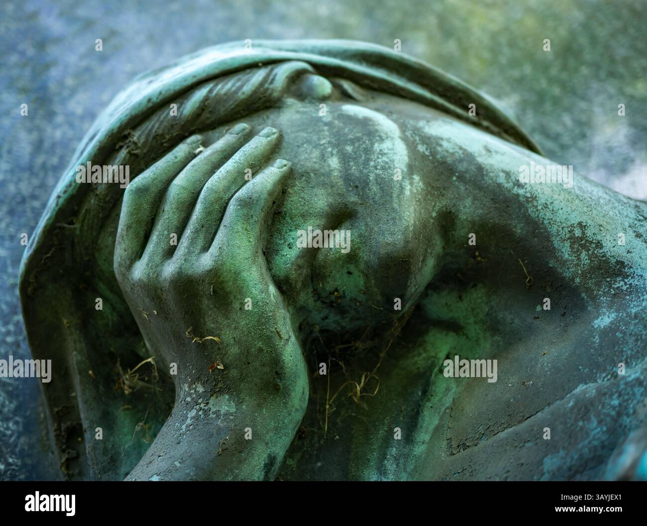 Nahaufnahme einer verwitterten Friedhofsstatue mit einer traurigen Geste – ein eindringliches Symbol für Depression und stille Leiden. Stockfoto
