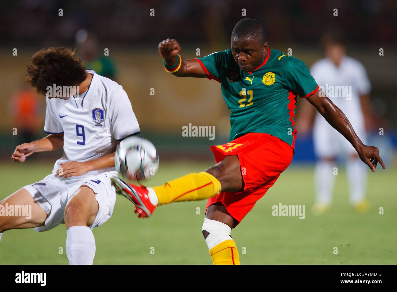 Andre Akono Effa aus Kamerun (21) räumt den Ball vor Kim Dong-Sub aus Südkorea (9) während eines Spiels der FIFA U-20-Weltmeisterschaft am 26. September 2009 in Suez (Ägypten). Nur redaktionelle Verwendung. Kein Pushing auf die Nutzung mobiler Geräte. Kommerzielle Nutzung verboten. (Foto: Jonathan Paul Larsen / Diadem Images) Stockfoto