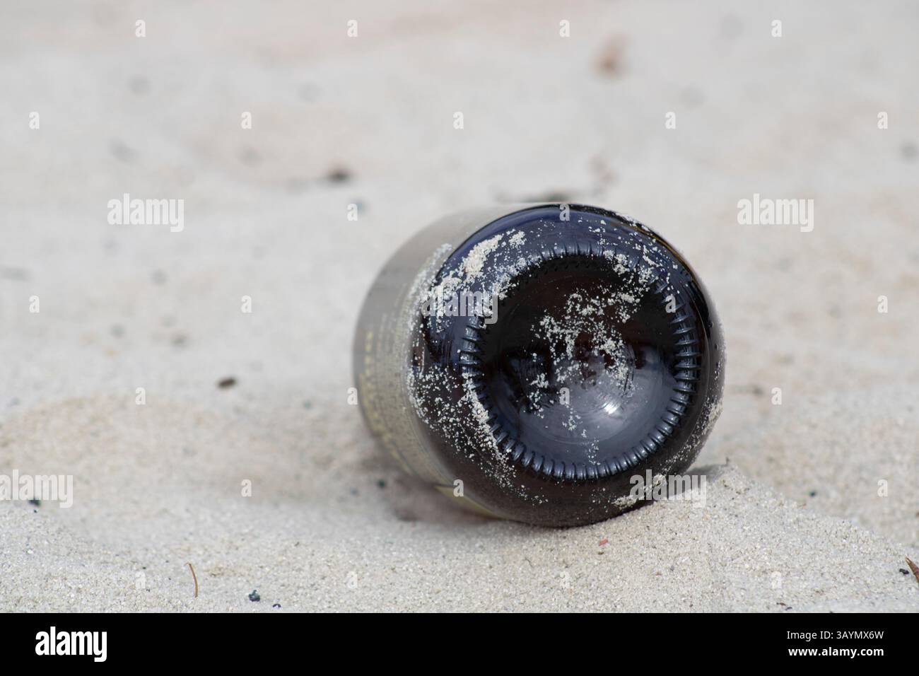 Braune Schnapsflasche in Sand Stockfoto