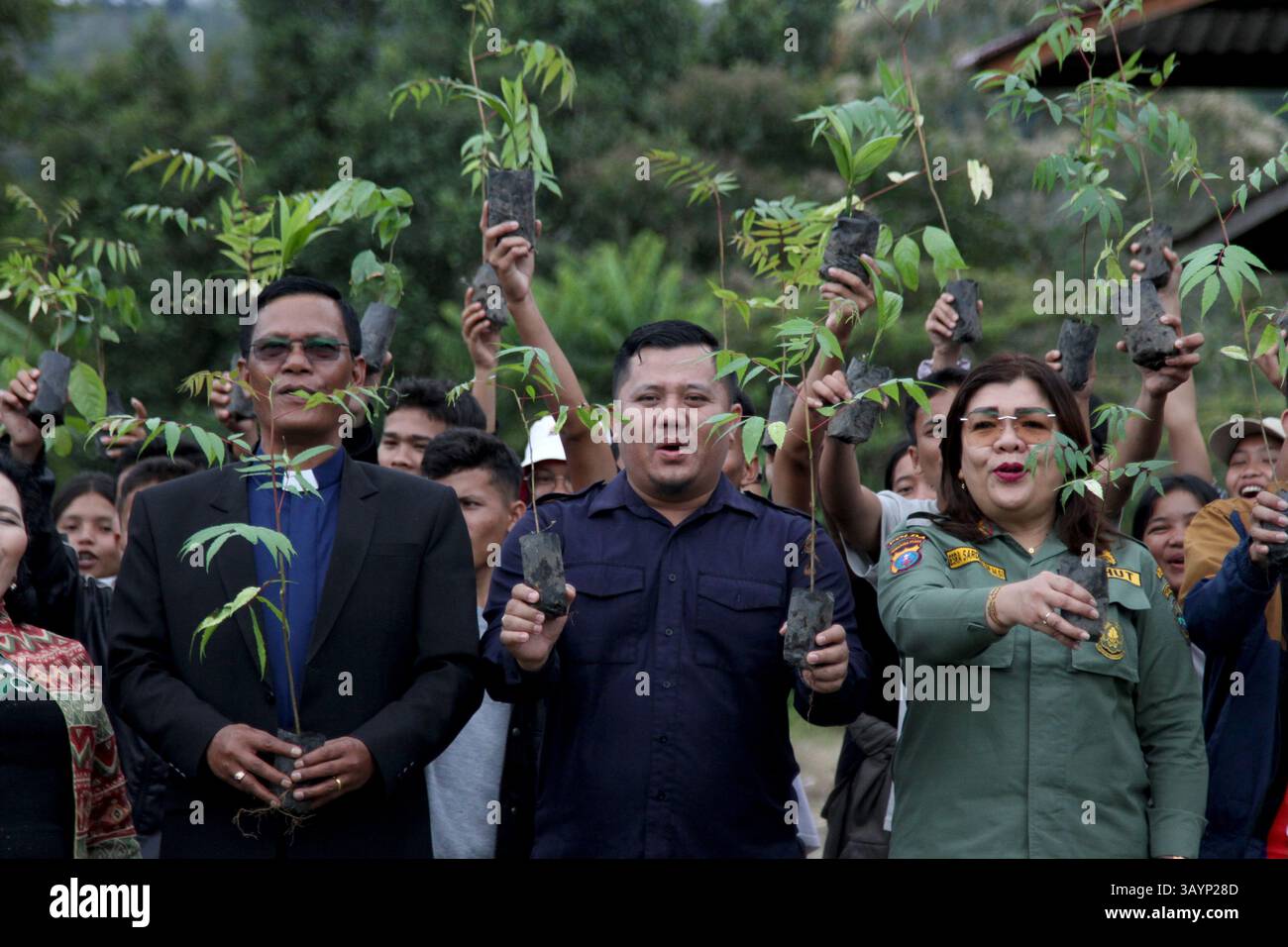 Humbang Hasundutan, Nordsumatrea, Indonesien. April 2025. Indra Nainggolan (Mitte), Mitglied der Humbang Hasundutan Regency DVRD von der Gerindra-Fraktion, hält gleichzeitig einen Baum, der zusammen mit der Gemeinde aus verschiedenen Elementen gepflanzt werden soll, als Teil einer echten Aktionskooperation zum Internationalen Tag der Erde 2025 im parlamentarischen Bezirk. Als Mitglied der DVRD, das in dem Gebiet beheimatet ist, lädt Indra alle Bewohner, junge Männer und Frauen im Gebiet des Tobasees ein, insbesondere diejenigen, die in den Gebieten Parlamentarier, Tarabintang und Humbang Hasundutan leben, gemeinsam diese Erde zu schützen. Stockfoto Humbang Hasundutan, Nordsumatrea, Indonesien. April 2025. Indra Nainggolan (Mitte), Mitglied der Humbang Hasundutan Regency DVRD von der Gerindra-Fraktion, hält gleichzeitig einen Baum, der zusammen mit der Gemeinde aus verschiedenen Elementen gepflanzt werden soll, als Teil einer echten Aktionskooperation zum Internationalen Tag der Erde 2025 im parlamentarischen Bezirk. Als Mitglied der DVRD, das in dem Gebiet beheimatet ist, lädt Indra alle Bewohner, junge Männer und Frauen im Gebiet des Tobasees ein, insbesondere diejenigen, die in den Gebieten Parlamentarier, Tarabintang und Humbang Hasundutan leben, gemeinsam diese Erde zu schützen. Stockfoto