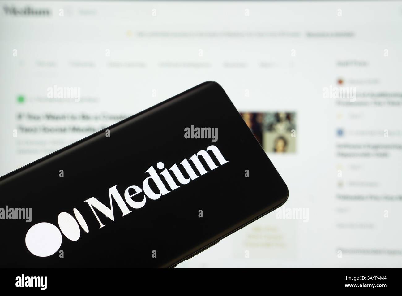 Dhaka, Bangladesch - 17. März 2025: Das Logo des Mediums wird auf einem Smartphone-Bildschirm angezeigt, und das Website-Medium ist auf einem Computerbildschirm sichtbar Stockfoto