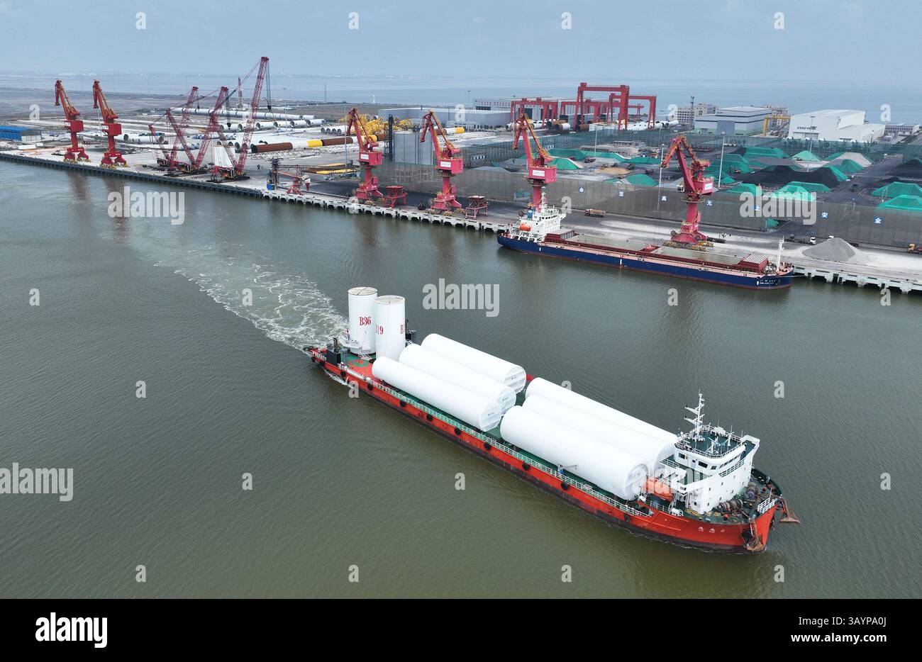 Schiff, das Windturbinentürme zur Installation zum Offshore-Windpark transportiert Stockfoto