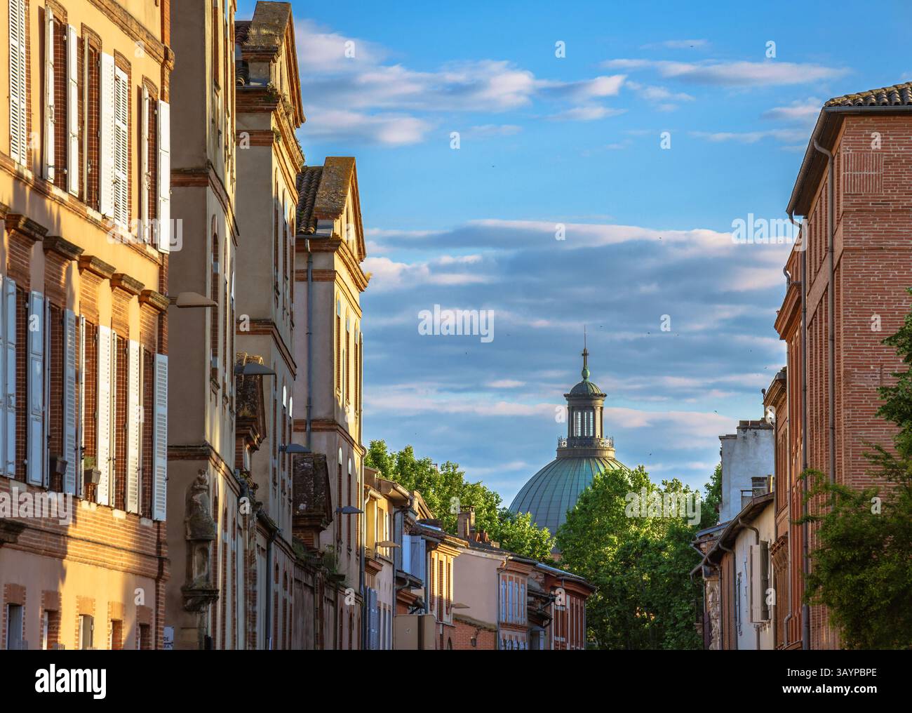 Die Wohnstraße führt in Richtung der berühmten Kuppel des Krankenhauses La Grave, beleuchtet von der goldenen Stunde Sonnenlicht, Toulouse, Frankreich Stockfoto