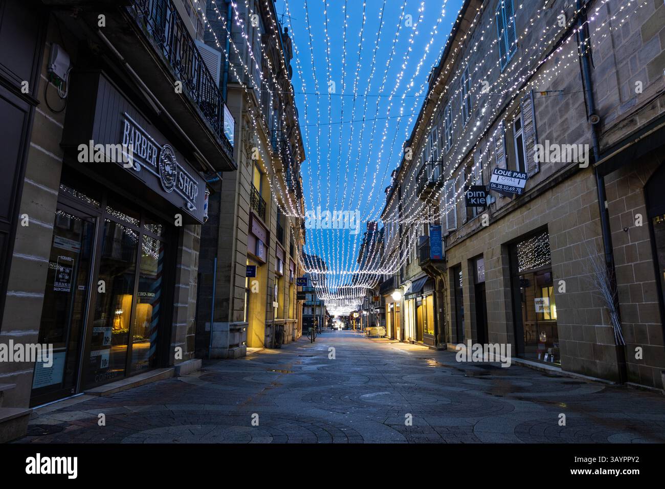 Eine Straße im historischen Stadtzentrum, die am frühen Morgen von Weihnachten und Neujahr beleuchtet wird. Brive-la-Gaillarde, Frankreich. Stockfoto
