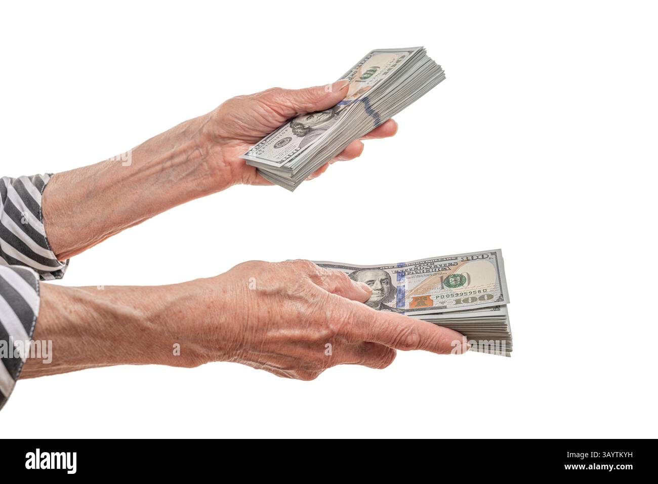 Ein älterer Mann überträgt einen dicken Stapel von US-Dollar-Scheinen Stockfoto