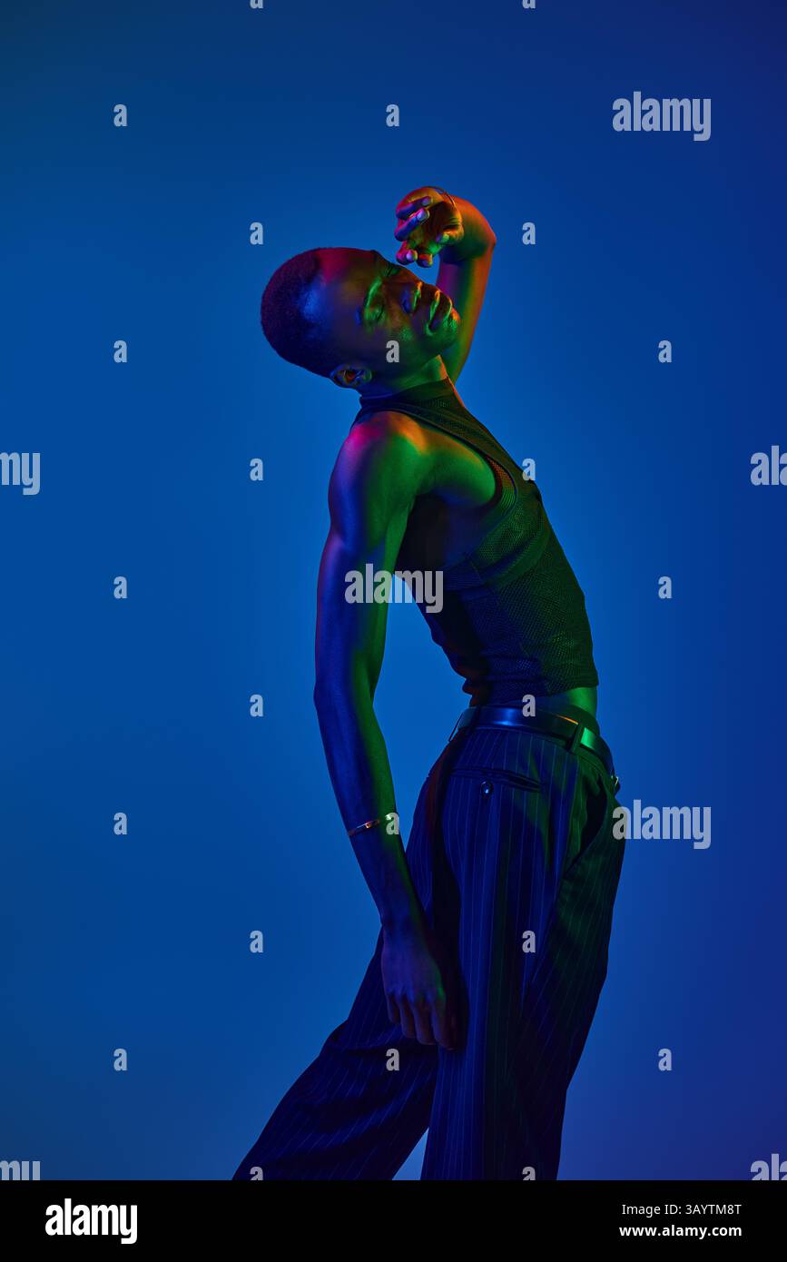 Ein junger afroamerikaner posiert elegant in stilvoller Kleidung vor einem hellen Hintergrund. Stockfoto