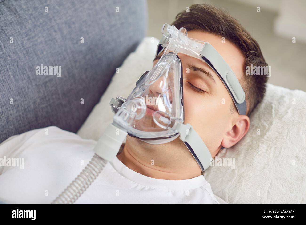 Porträt Eines Menschen, Der Durch Sauerstoffmaske Schläft Und Inhaliert Stockfoto