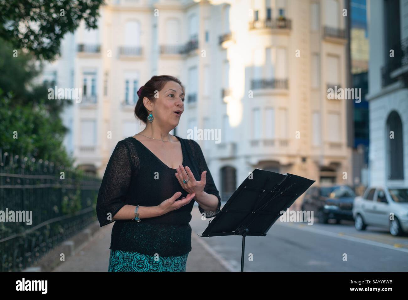 Sopran singt Oper in einer eleganten Straße mit einem Notenständer Stockfoto