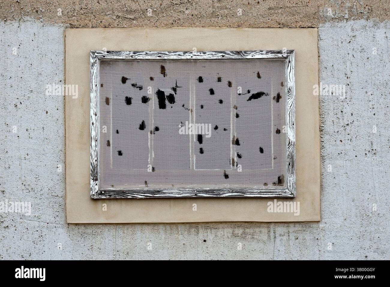 Ein altes, verwittertes Fliegengitter, eingerahmt in einem rustikalen Holzrahmen, montiert auf einer rauen Betonwand. Stockfoto Ein altes, verwittertes Fliegengitter, eingerahmt in einem rustikalen Holzrahmen, montiert auf einer rauen Betonwand. Stockfoto