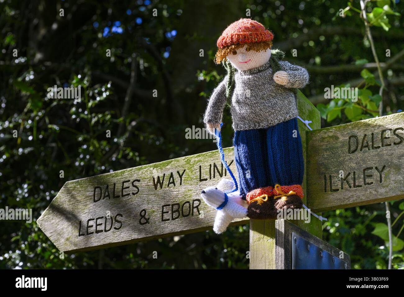 Yarnbombe Person am Fingerpfosten befestigt (öffentlicher Fernwanderweg, Ebor Way, Dales Way Link) Nahaufnahme - Menston, West Yorkshire, England Großbritannien. Stockfoto
