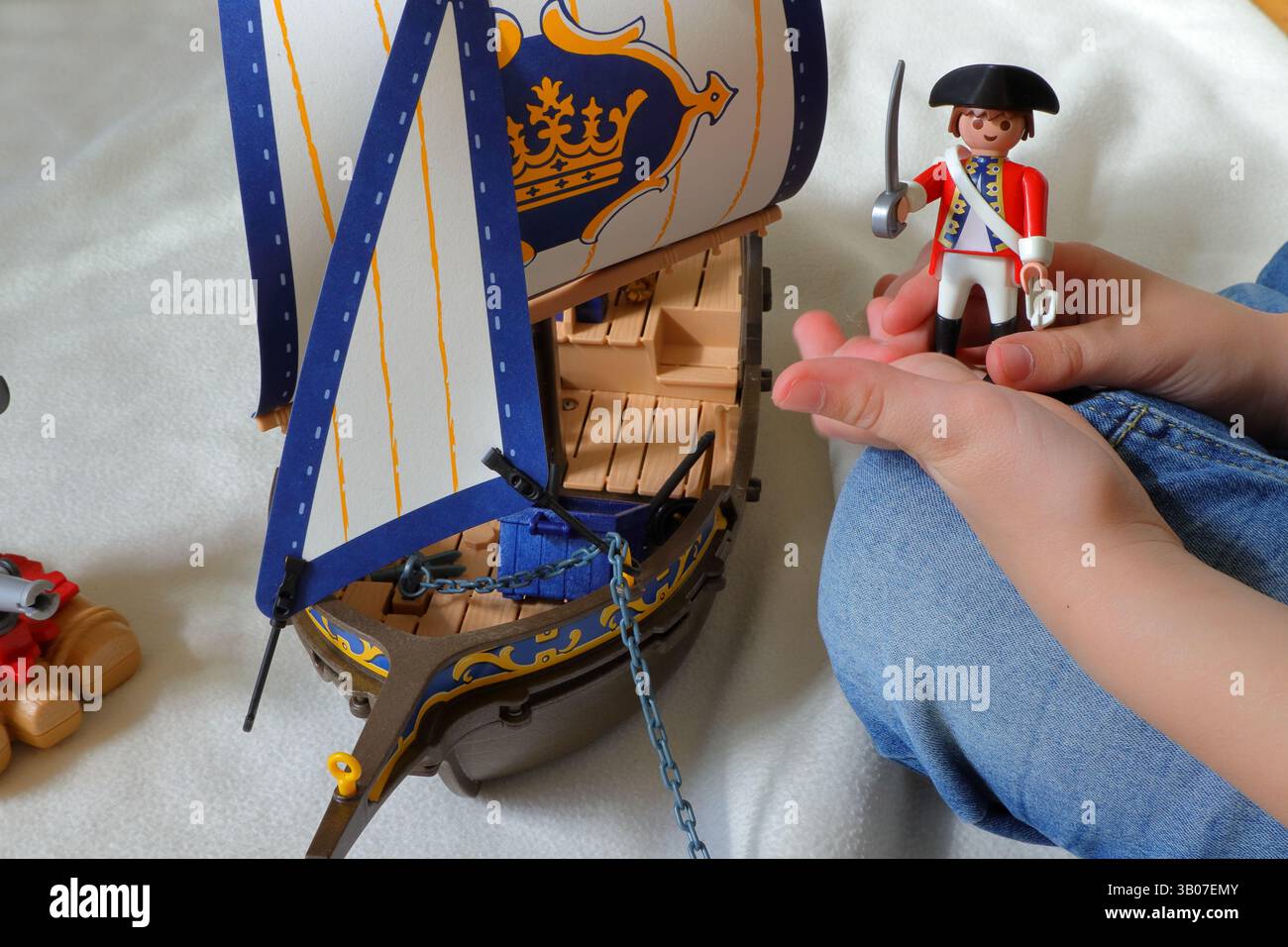Ein Kind spielt mit playmobil-Piraten und britischen Rotwanzsoldaten. Kein Gesicht, nur Hände sichtbar. Stockfoto