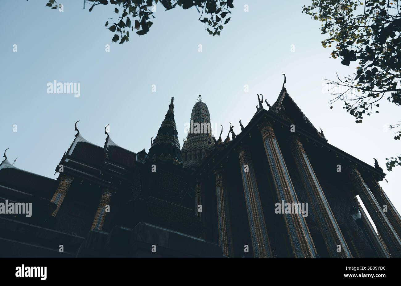 Goldene Säulen und Türme des Wat Phra Kaew reichen in den Himmel, während die Dämmerung einbricht Stockfoto