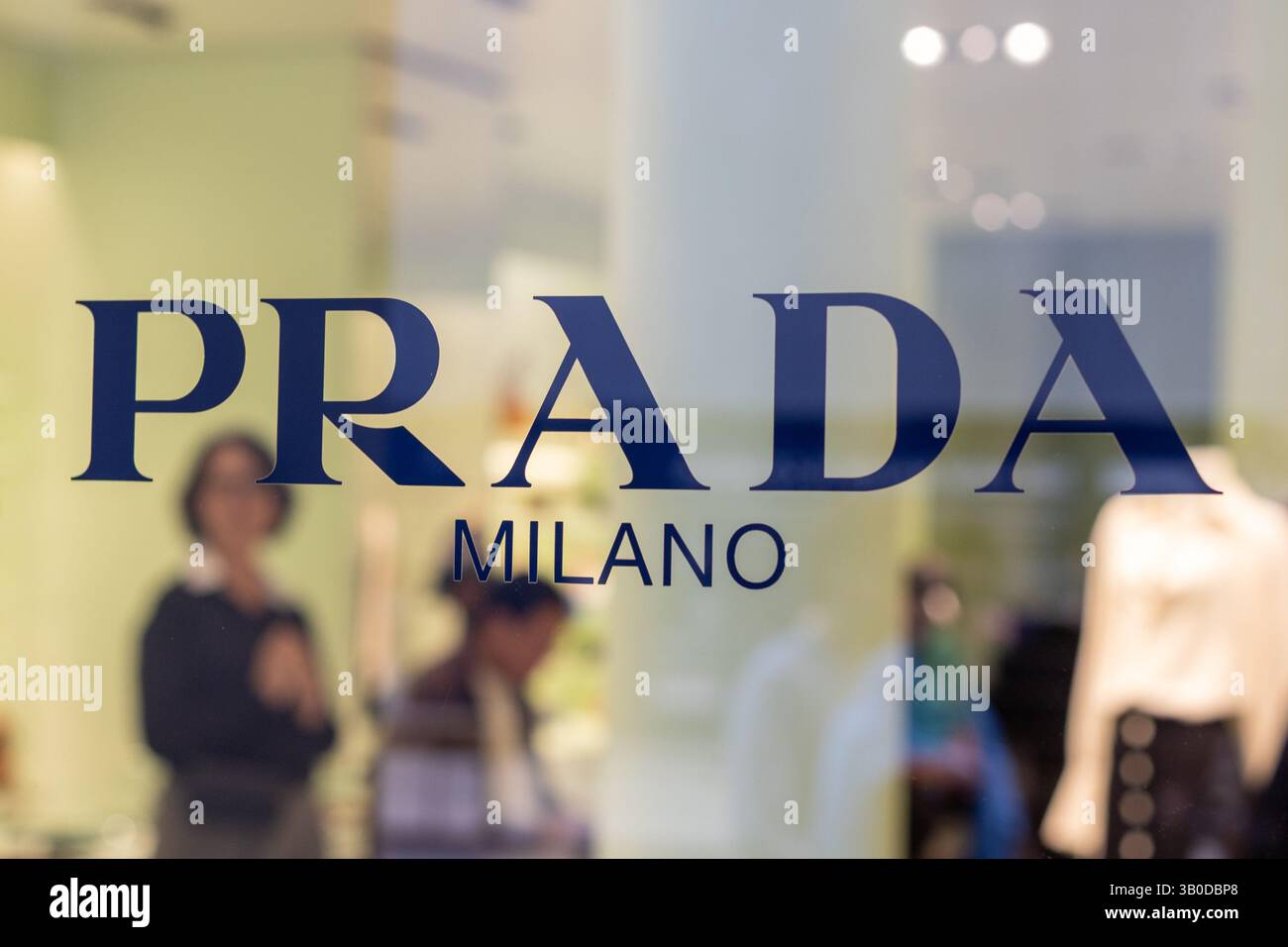 Venedig, Italien - 20. April 2025: Glasfensterlogo der Prada Milano Boutique mit Innenspiegelung Stockfoto