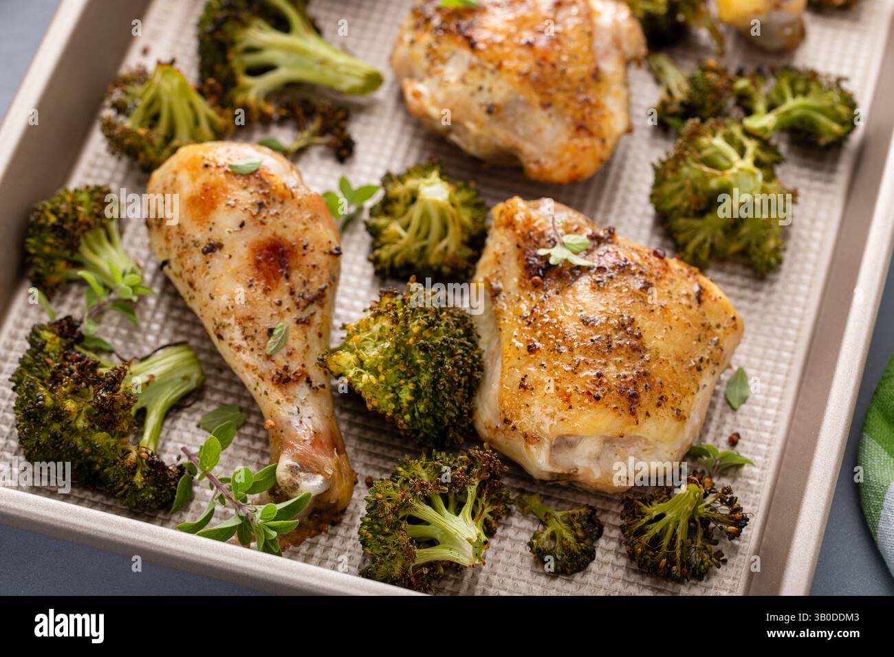 Im Ofen gebratenes Hähnchen mit Brokkoli auf einer Pfanne, einfaches Abendessen oder Mittagessen Stockfoto