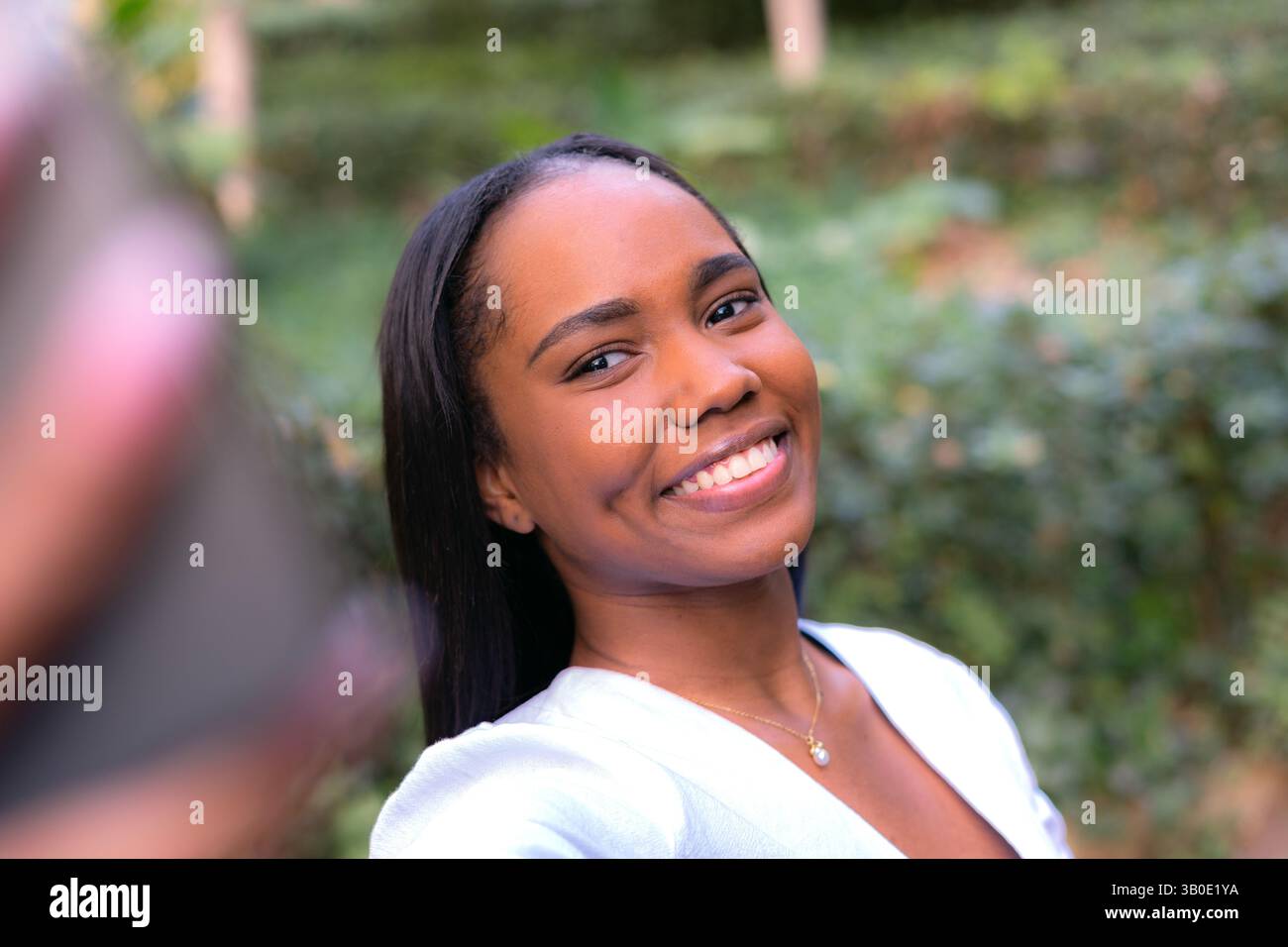 Eine fröhlich lächelnde Frau macht glücklich ein Selfie inmitten der Schönheit der Naturlandschaft Stockfoto