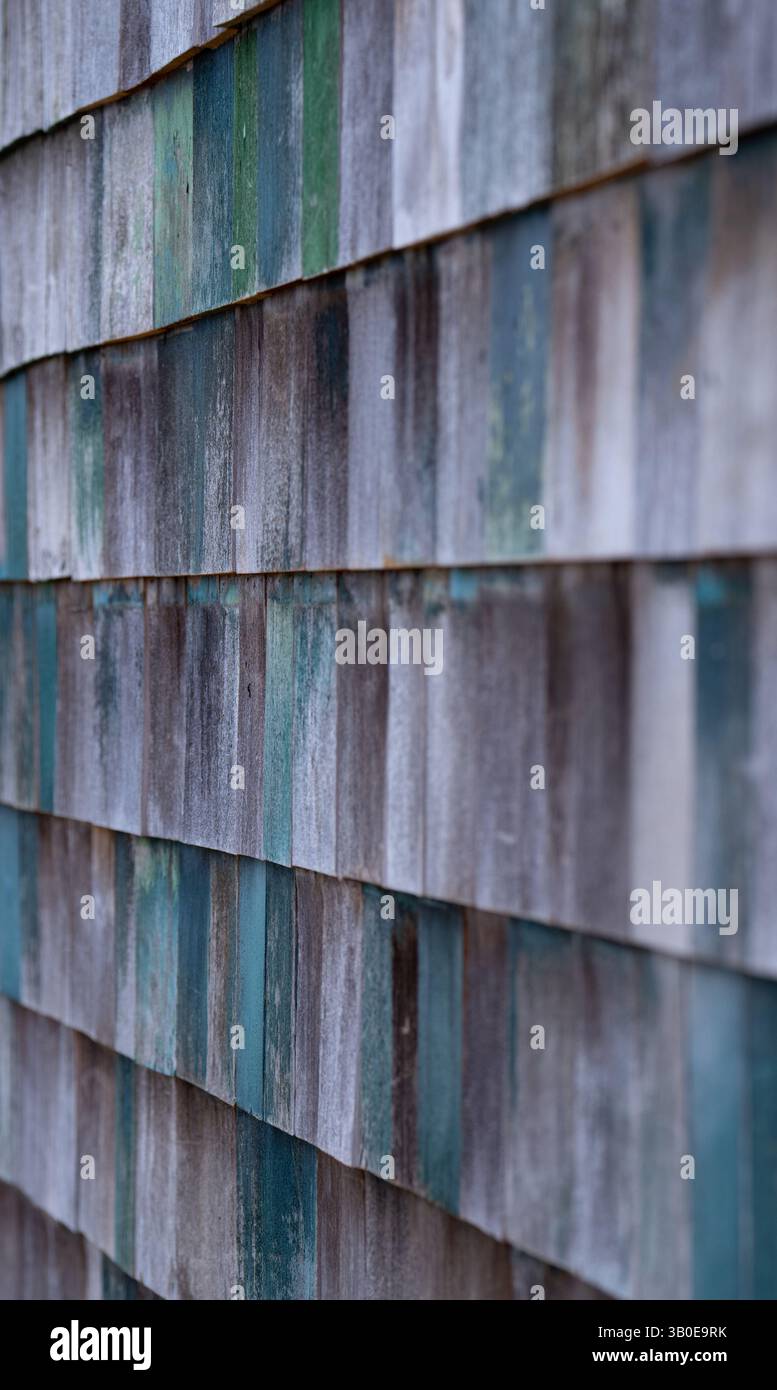 Holz schüttelt Schindeln an der Seite des alten Gebäudes gemalte Grüntöne und verblasste vertikale Bilder, die von Schichten einzelner Holzquadrate aufgenommen wurden Stockfoto