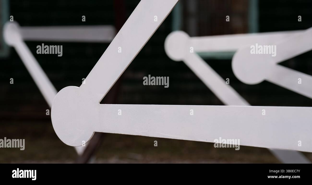 Nahaufnahme von weißen geometrischen Formen von Balken mit Kreisen an den Enden, die Dreiecksformen mit schwarzem Hintergrund erzeugen Leeren gerahmten Platz für Text Stockfoto