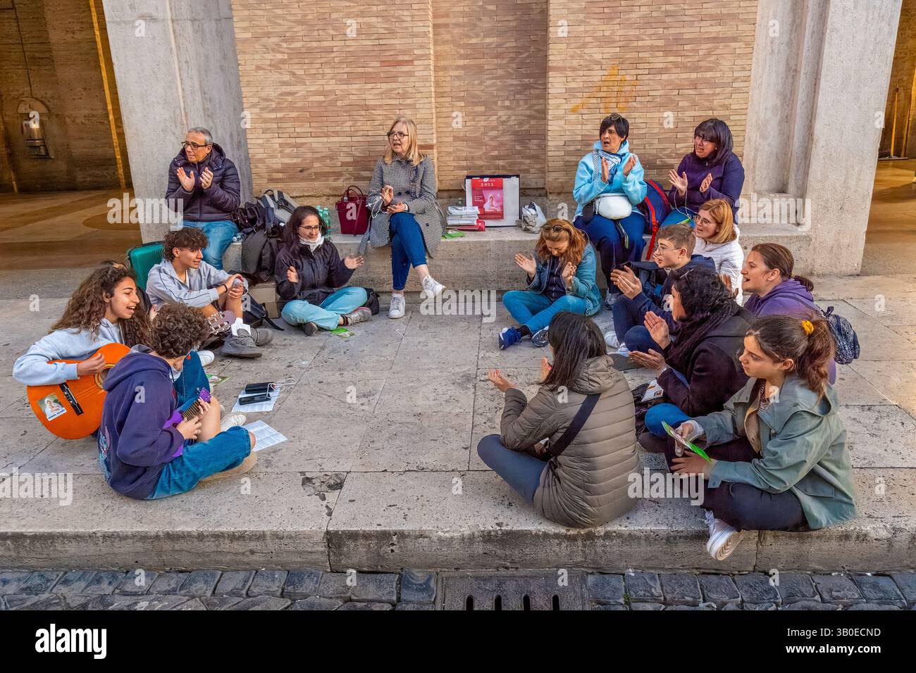 Junge Gläubige singen und beten auf dem Petersplatz an den Tagen der Hommage an den Leichnam von Papst Franzesco, Vatikanstaat, Rom, Italien Stockfoto