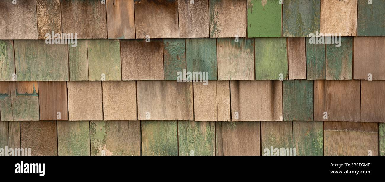 Horizontales Farbbild von verblassten grün blau lackierten Holzschindeln oder Schütteln an der Außenwand des alten Gebäudes und Schindeln in Reihen Stockfoto