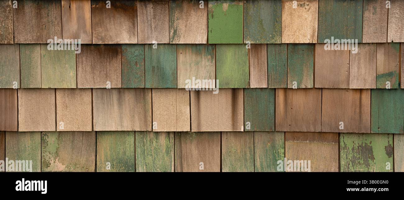 Horizontales Farbbild von verblassten grün blau lackierten Holzschindeln oder Schütteln an der Außenwand des alten Gebäudes und Schindeln in Reihen Stockfoto