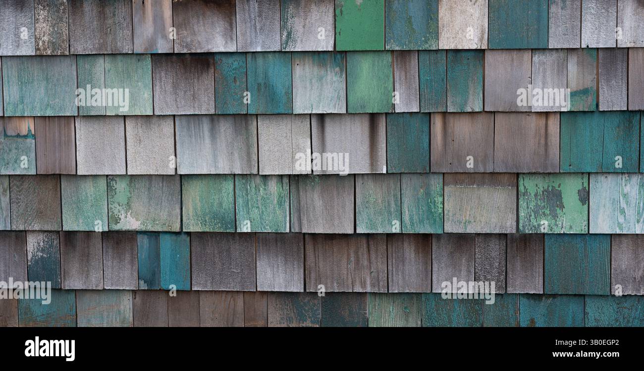 Horizontales Farbbild von verblassten grün blau lackierten Holzschindeln oder Schütteln an der Außenwand des alten Gebäudes und Schindeln in Reihen Stockfoto
