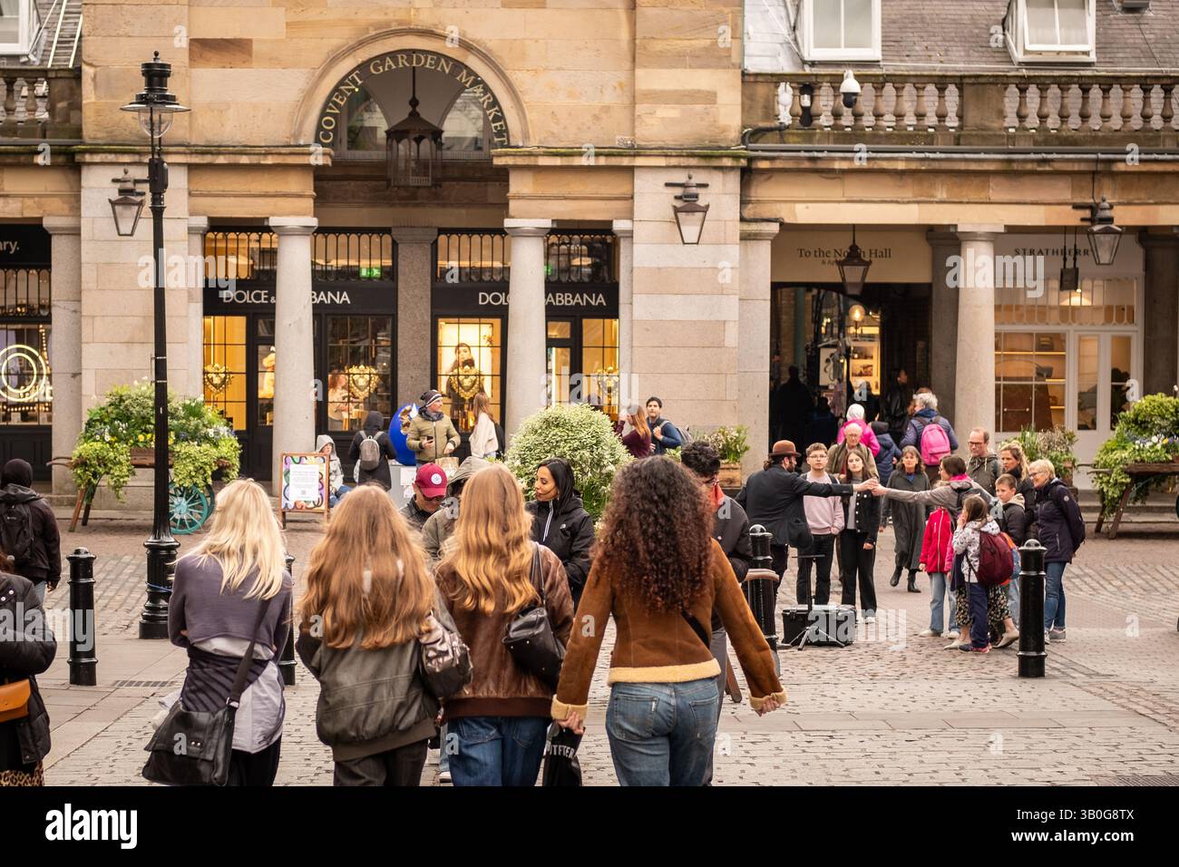 LONDON - 23. APRIL 2025: Junge Leute kaufen in offener Straßenansicht des Covent Garden-Viertels im Londoner West End ein. Stockfoto