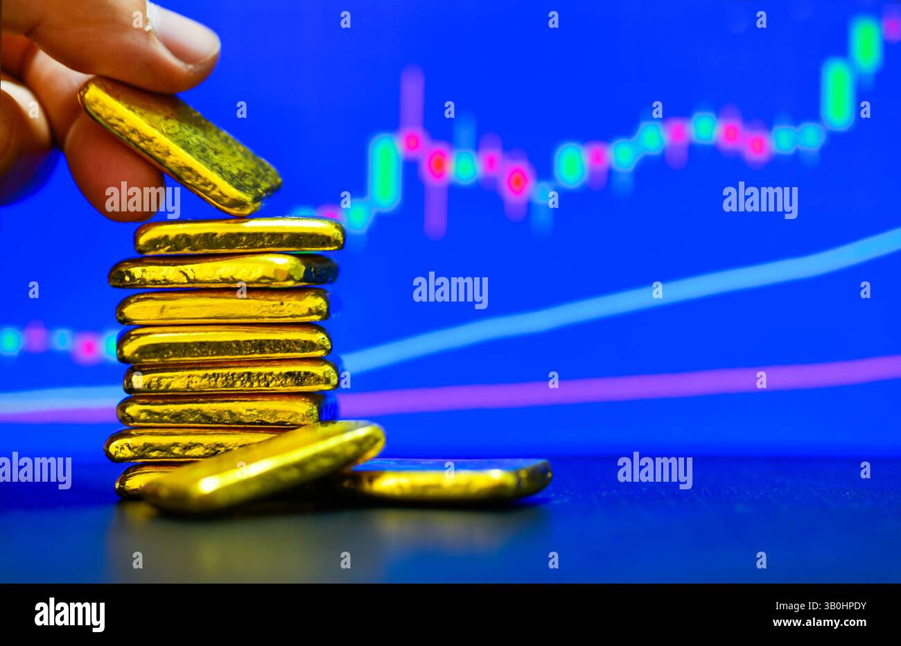 Foto ein Goldbarren der Hintergrund der Kerzendiagramme, Schwankungen der Goldpreise Konzept. Stockfoto