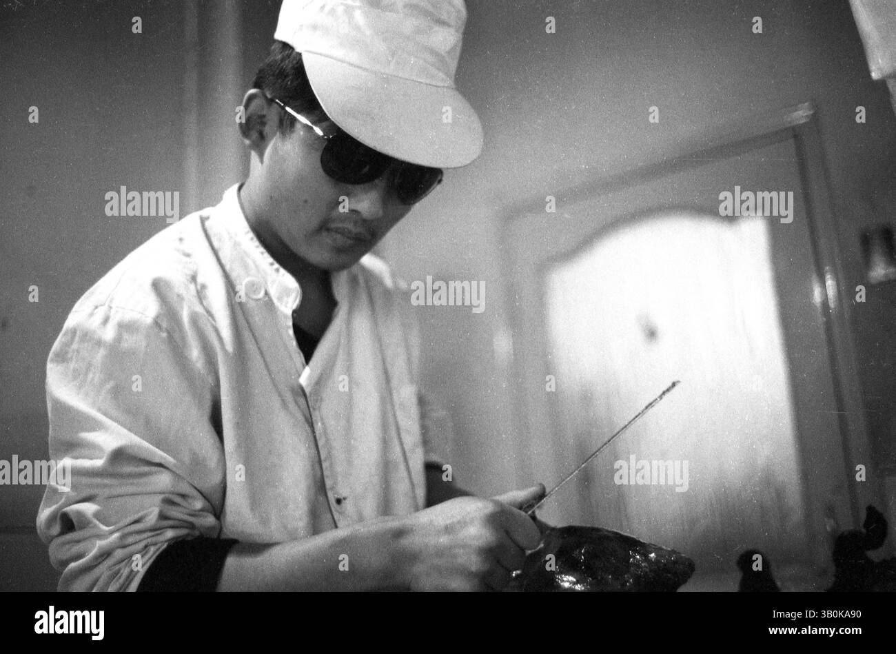 Chef Carving Roast Ente in Schwarz-weiß Film Kitchen Scene, 2010er Jahre, Tianjin, China Stockfoto