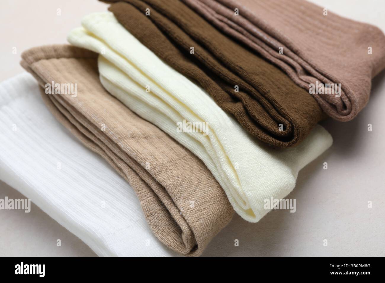 Verschiedene weiche Socken auf hellbeigem Hintergrund, Nahaufnahme Stockfoto
