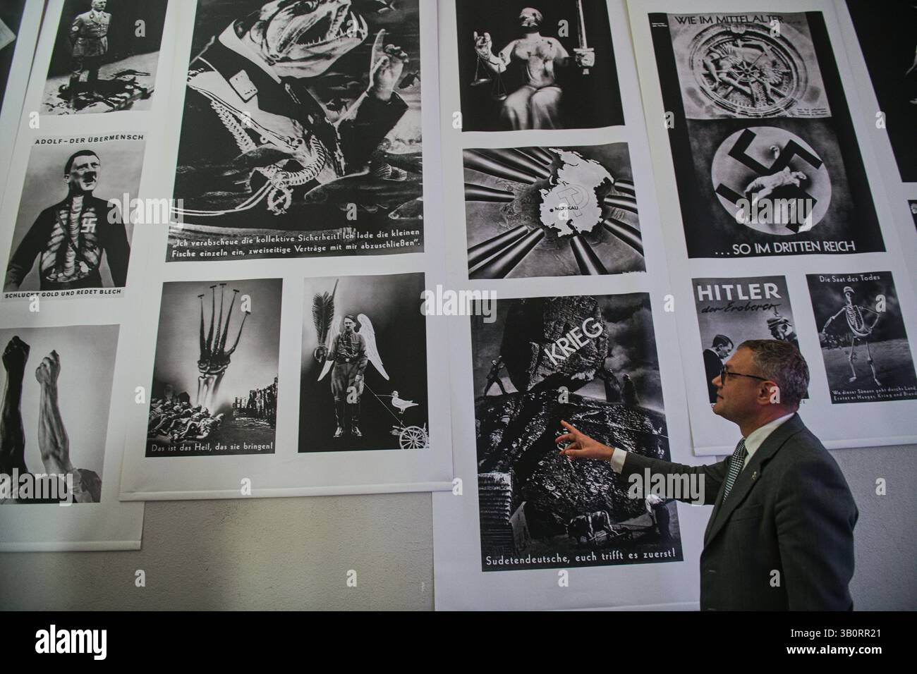 Anlässlich des 80. Jahrestages des Endes des Zweiten Weltkriegs hat das Stadtmuseum Brünn die Eröffnung der Ausstellung "Kreuzkapelle" vorbereitet. Die dramatische Reise von der barocken Frömmigkeit zur totalitären Ideologie“, dargestellt am 24. April 2025 im Schloss Spilberk in Brünn, Tschechische Republik. Während des Zweiten Weltkriegs verwandelte die Wehrmacht die Kapelle in einen Propagandaraum mit Nazi-Symbolen. Das Bild zeigt den Direktor des Brünner Stadtmuseums, Zbynek Solc, mit Fotomontagen des deutschen bildenden Künstlers John Heartfield. (CTK Foto/Patrik Uhlir) Stockfoto