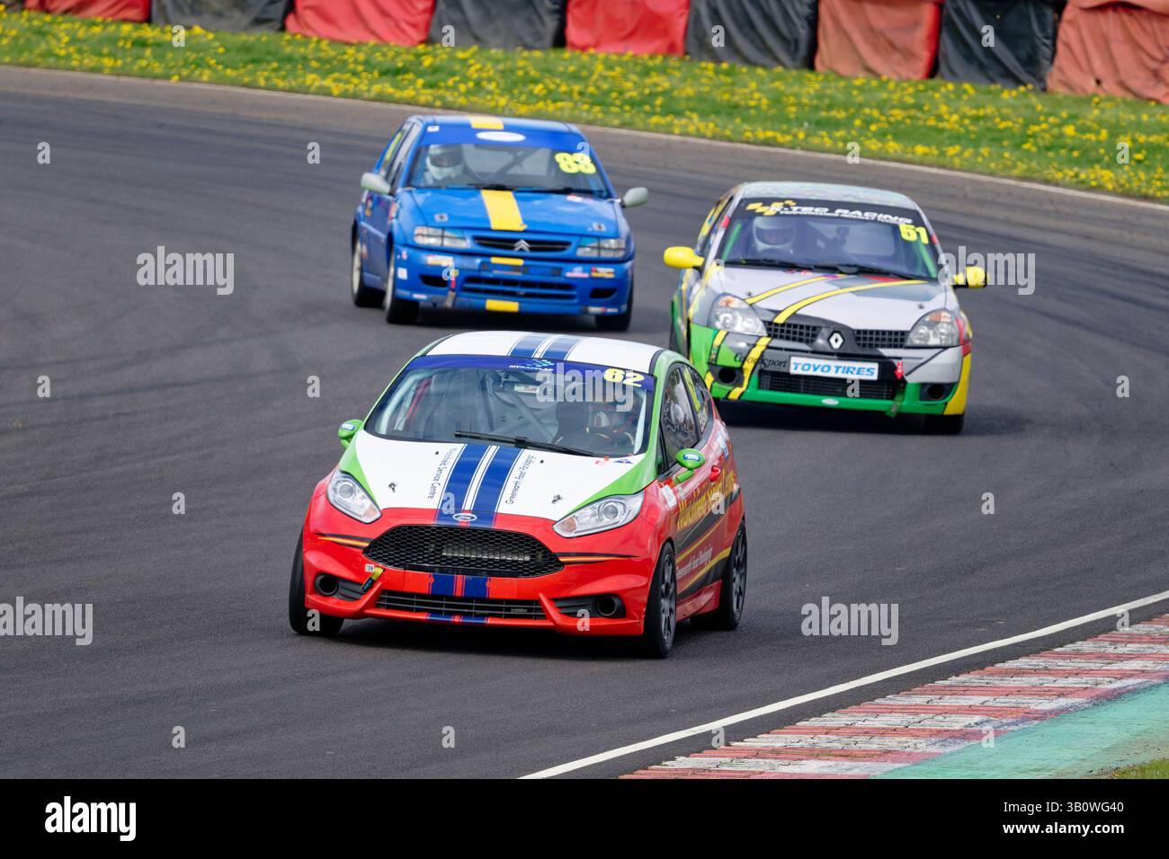 Julian Ellison durchquert in seiner Ford Fiesta während des CCRC Hot Hatch Rennens auf Castle Combe einen Steinbruch, gefolgt von Jake Humphrey in einem Renault Clio Stockfoto