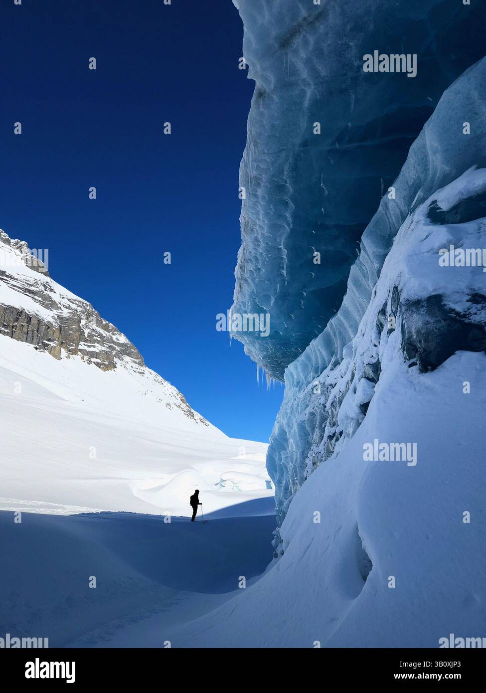 BEI Skifahrern unter Eisfall am Fuß des Gletschers, Mons Peak, Canadian Rockies. Stockfoto