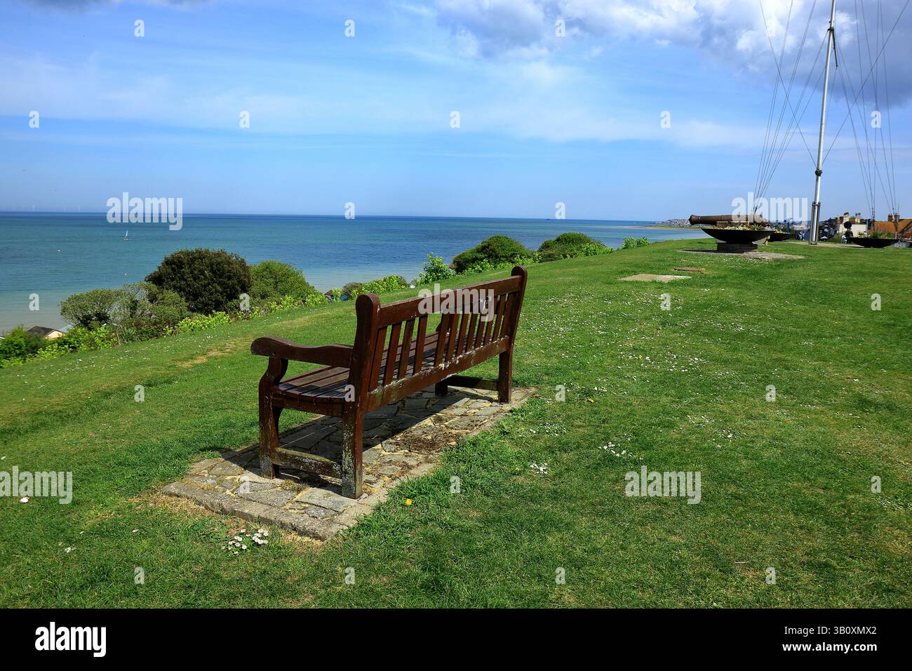 Eine hölzerne Parkbank und ein alter Kanon mit Blick auf das Meer von Tankerton Stockfoto