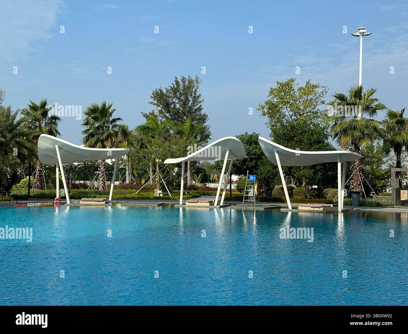 Wunderschöne Poolszene des Resorts mit stilvollen Baldachin-Strukturen und blauem Wasser. - Smartphone-aufgenommenes Stockfoto