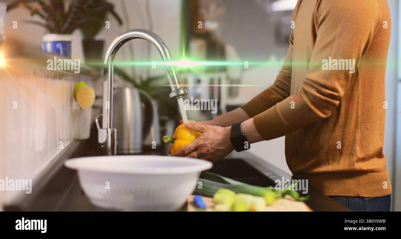 Bild des Lichts, das sich über den Mittelteil des kaukasiers bewegt, der Gemüse in der Küche wäscht Stockfoto