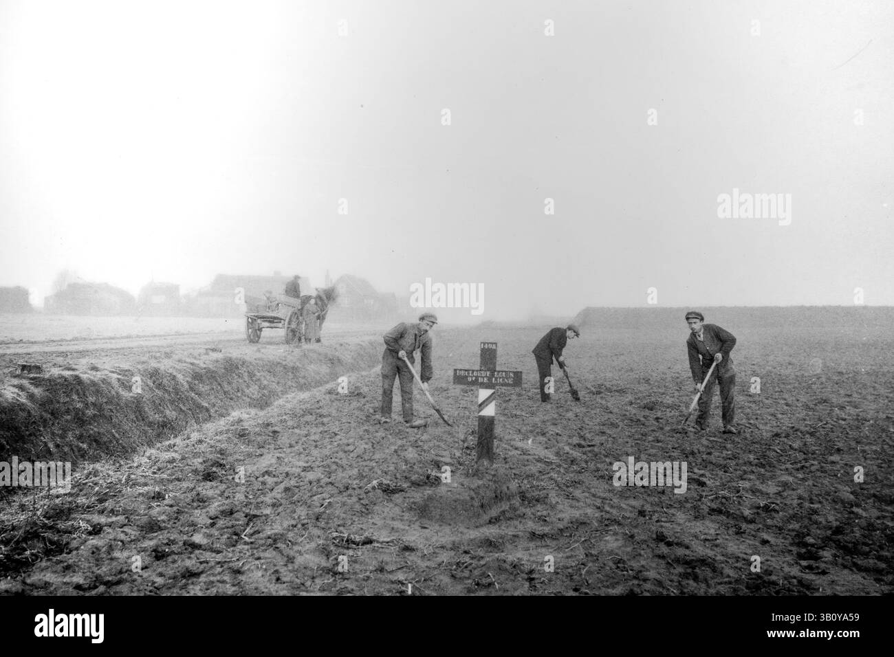 Hölzernes Kreuz auf dem Grab gefallener Soldaten und Arbeiter, die das Feld nach dem Ersten Weltkrieg in Westflandern, Belgien, auf dem ehemaligen Schlachtfeld ebneten Stockfoto